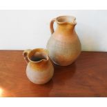 TWO 19TH CENTURY TERRACOTTA PART SALT GLAZE WATER JUGS, 31cm high and 19cm high