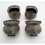 A SET OF FOUR INDIAN SILVERED BOWLS, with embossed foliate decoration and pierced fret work rims,