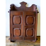 AN ARTS AND CRAFTS WALL MOUNTED CABINET, with panelled doors and fitted shelf, 85 x 53cms