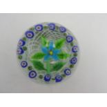 A MURANO GLASS MILLEFIORE PAPERWEIGHT, with swirl design and a central floral motif, 9cm dia