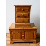 A MODERN PINE 3-DRAWER BEDSIDE CHEST AND LOW PINE 2-DOOR CABINET, the chest 61 x 44 x 36cms