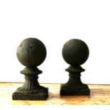 A PAIR OF WEATHERED SPHERICAL SHAPED GARDEN FINIAL PILLAR TOPS ON TAPERED PLINTHS, 65cm high