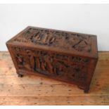 AN ORNATE CARVED CAMPHORWOOD BLANKET CHEST , with two carved handles and claw feet,  62 x 98 x 54 cm