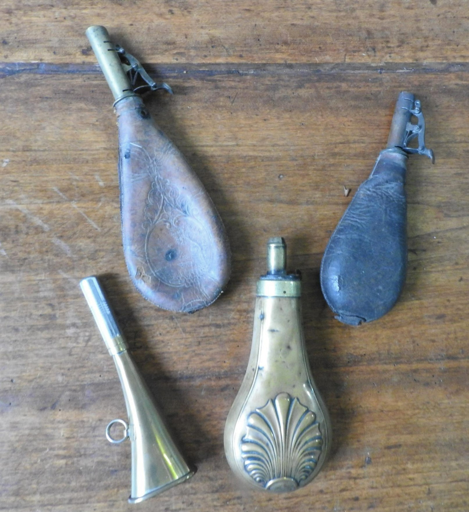 A 19TH CENTURY BRASS SHOT FLASK, TWO LEATHER SHOT FLASKS AND A 20TH CENTURY HUNTING HORN, the