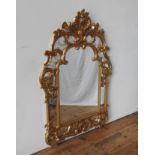 AN ORNATE CONTEMPORARY ROCOCO-STYLE GILT FRAMED WALL MIRROR, 145 x 95 cm