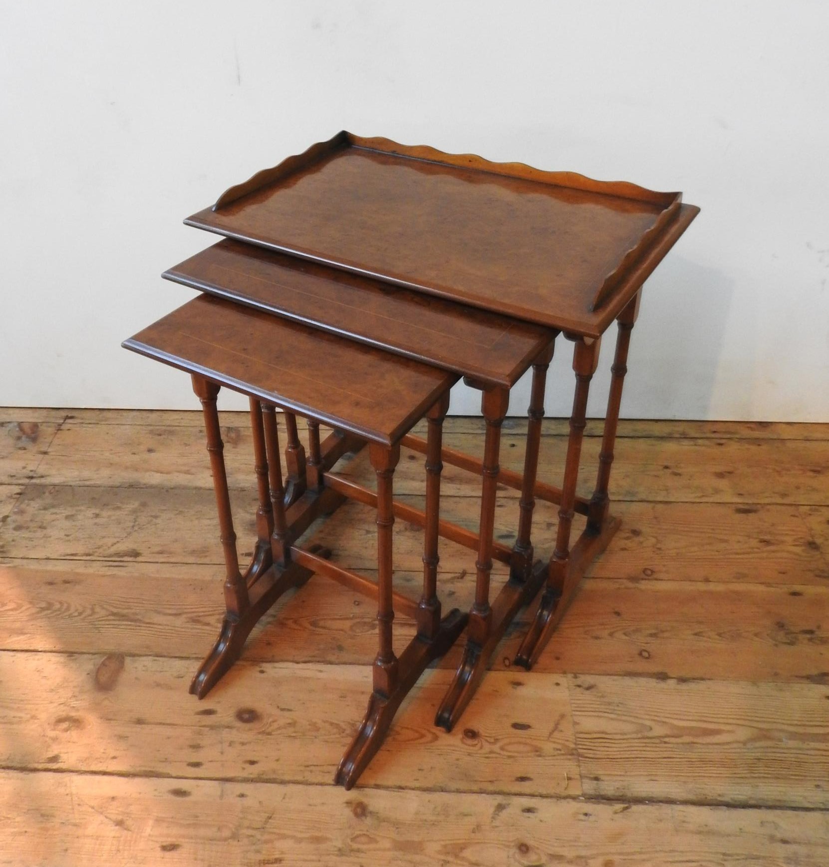 A BRIGHTS OF NETTLEBED NEST OF THREE BURR WALNUT TABLES, all with turned spindle legs, the largest