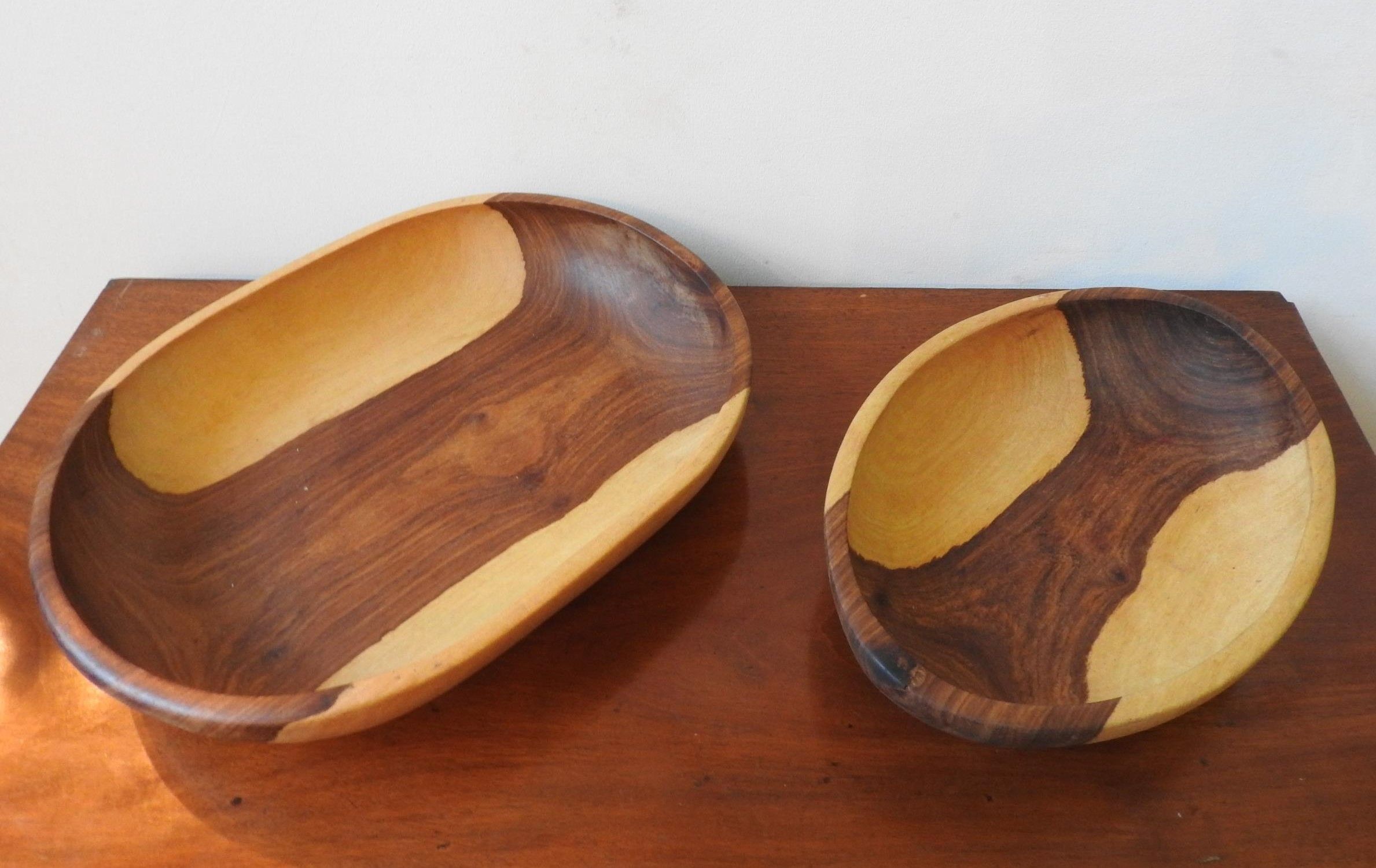 TWO CARVED INDIGENOUS WOODEN BOWLS, one obong and one oval, 42 x 32cm and smaller