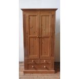 A PINE PANELLED WARDROBE, A PINE WARDROBE WITH TOP LOCKER A ND A PINE CHEST OF SIX DRAWERS, and a