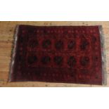A HAND KNOTTED BORDER PATTERN RED GROUND RUG, with repeating geometric pattern 190 x 130 cm