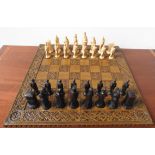 A 20th CENTURY COMPLETE CHESS SET AND CHESS BOARD, in a medieval style, the board 60cm square, the