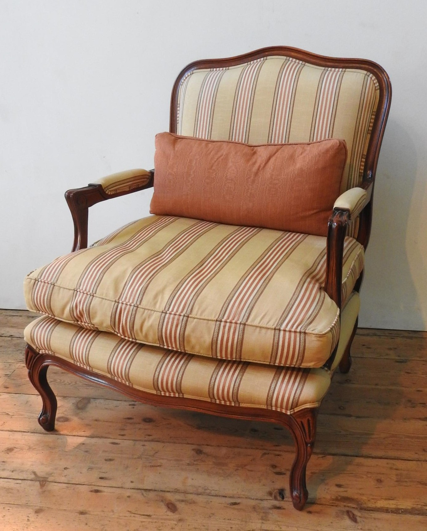 A WADE UPHOLSTERY 'RIMINI' ARMCHAIR AND FOOTSTOOL, both upholstered in gold and burgundy pinstripe