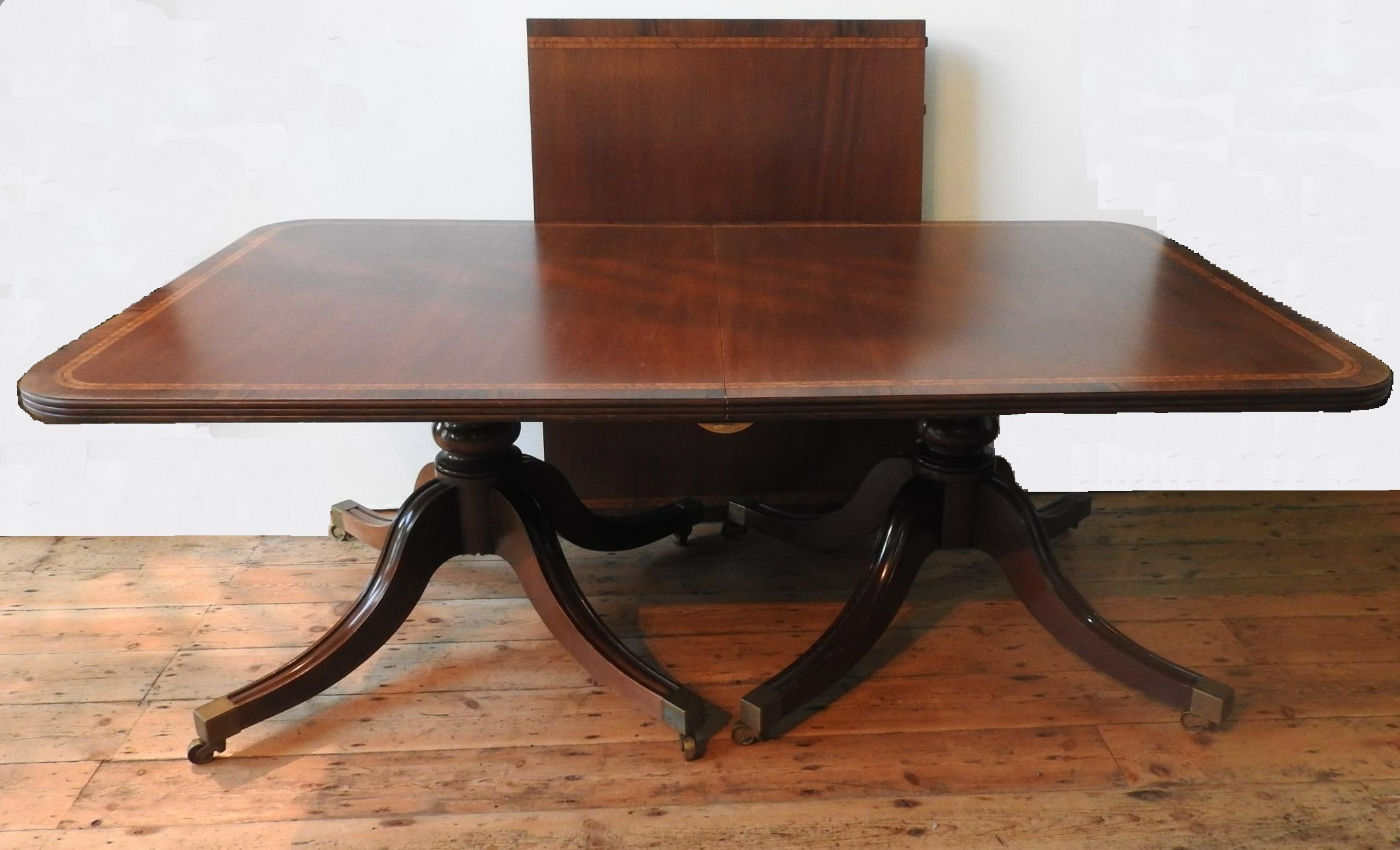 A 20TH CENTURY TWIN PEDEDSTAL D-END CROSS BANDED DINING TABLE AND 6 DINING CHAIRS, with tilting