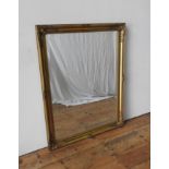 A MODERN SWEPT GILT FRAMED BEVELLED WALL MIRROR, 117 x 90 cm