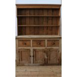 A RUSTIC PINE THREE DOOR KITCHEN DRESSER WITH 3-TIER PLATE RACK, the base comprised of three deep