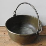 A 19TH CENTURY HAMMERED BRASS BUCKET WITH IRON RING HANDLE, 48.5 cm diameter