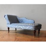 A CHILD'S DAMASK UPHOLSTERED CHAISE LONGUE, covered in teal blue fabric with embroidered foliate