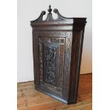 A CONTINENTAL OAK 19TH CENTURY ORNATE CARVED CORNER CUPBOARD, with scroll and finial pediment and