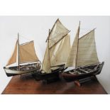 THREE 20TH CENTURY WOODEN MODEL SAIL BOATS, with display stands, the largest 62cm high x 58 cm long