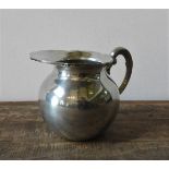 A BOLIVIAN PEWTER WATER JUG, with lotus flower decorated edge, 15 cm high