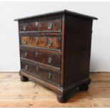A 19TH CENTURY MAHOGANY AND WALNUT CHEST OF FOUR DRAWERS ON BUN FEET, with brass ring handles, 61