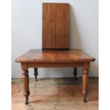 AN EDWARDIAN MAHOGANY WIND-OUT EXTENDING DINING TABLE, with extra leaf insertion, on turned legs
