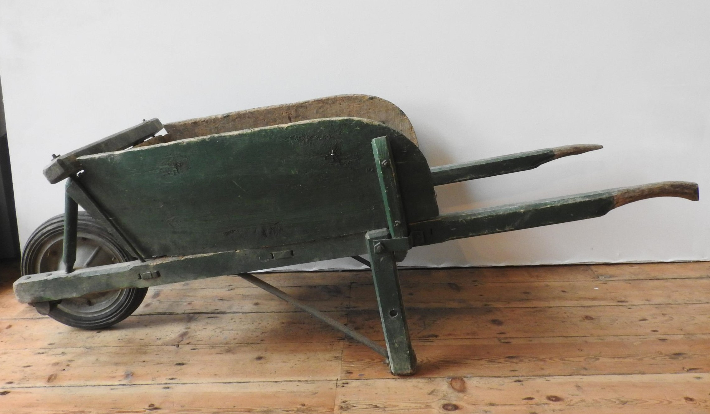 A FRENCH RUSTIC GREEN PAINTED WHEELBARROW, the original wheel replaced with a later addition, 63 x