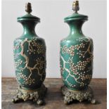 A PAIR OF 19th CENTURY CHINESE GREEN GLAZED TABLE LAMPS,  EMBOSSED WITH BLOSSOM PATTERN ON ORNATE