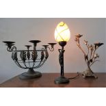 A CONTEMPORARY FIGURINE TABLE LAMP AND A CAST METAL FLORAL DECORATED CANDELABRA,  with a