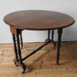 A VICTORIAN MAHOGANY SUTHERLAND TABLE, the folding circular top supported on turned legs and