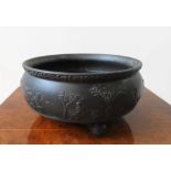 A WEDGEWOOD BLACK BASALT BOWL DECORATED WITH CLASSICAL SCENE, with a foliate border on three ball