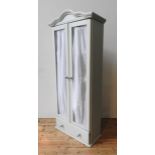 A PAINTED FRENCH STYLE TWO DOOR CUPBOARD WITH MATERIAL DOOR HANGINGS AND DRAWER BELOW
