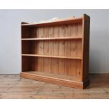 A PINE FOUR TIER BOOKSHELF, with serpentine gallery back, 103 x 122 x 24 cm