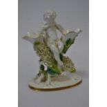 Moore Brothers porcelain double trumpet vase, late 19th century, modelled as a putto seated in a flo