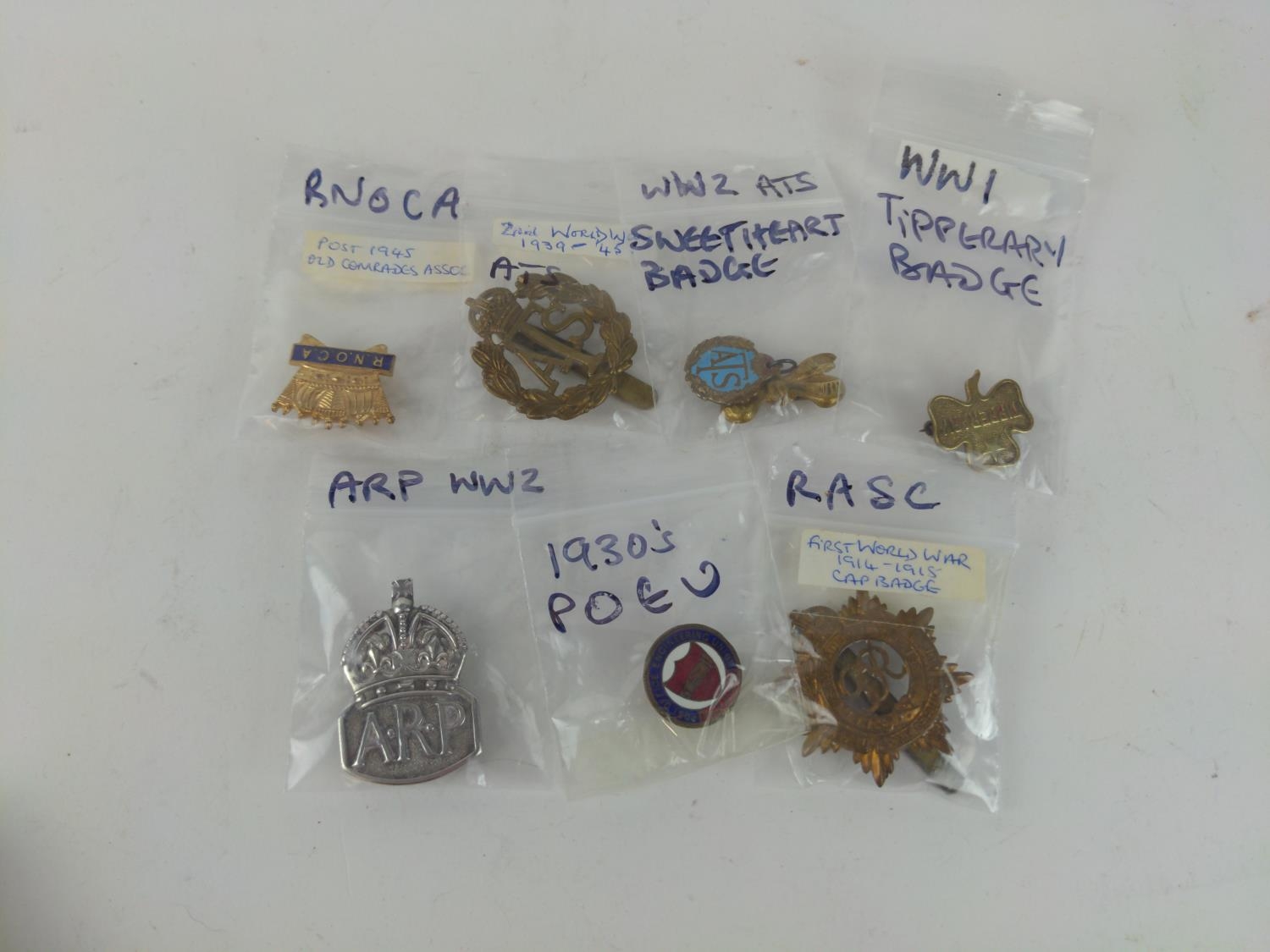 Collection of seven WWI & WWII badges including silver ARP badge, ATS cap badge, ATS sweetheart badg