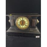 Metal mantle clock with enamel face, flanked with brass lion head, W38cm h25cm.