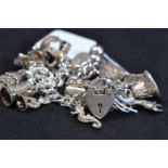 Silver charm bracelet with silver and white metal charms, gross weight 65g