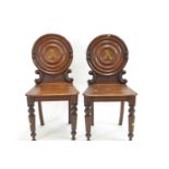 Pair of bullseye back oak hall chairs, with inset 'A' brass letters