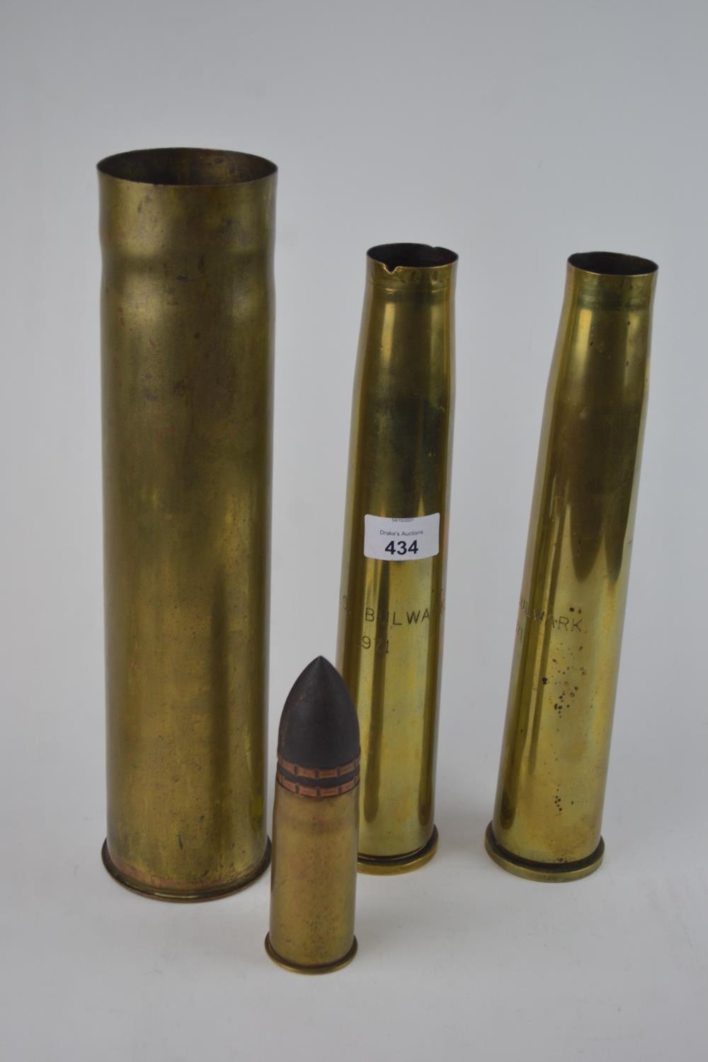 Four shell cases, including two marked H.M.S. Bulwark 1971 