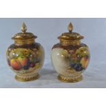 Pair of Royal Worcester pot pourri vases with covers, dated 1925, painted with fruit on forest floor