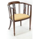 An Edwardian mahogany tub chair, with inlay detail &amp; arrow supports. W54cm d44cm h76cm