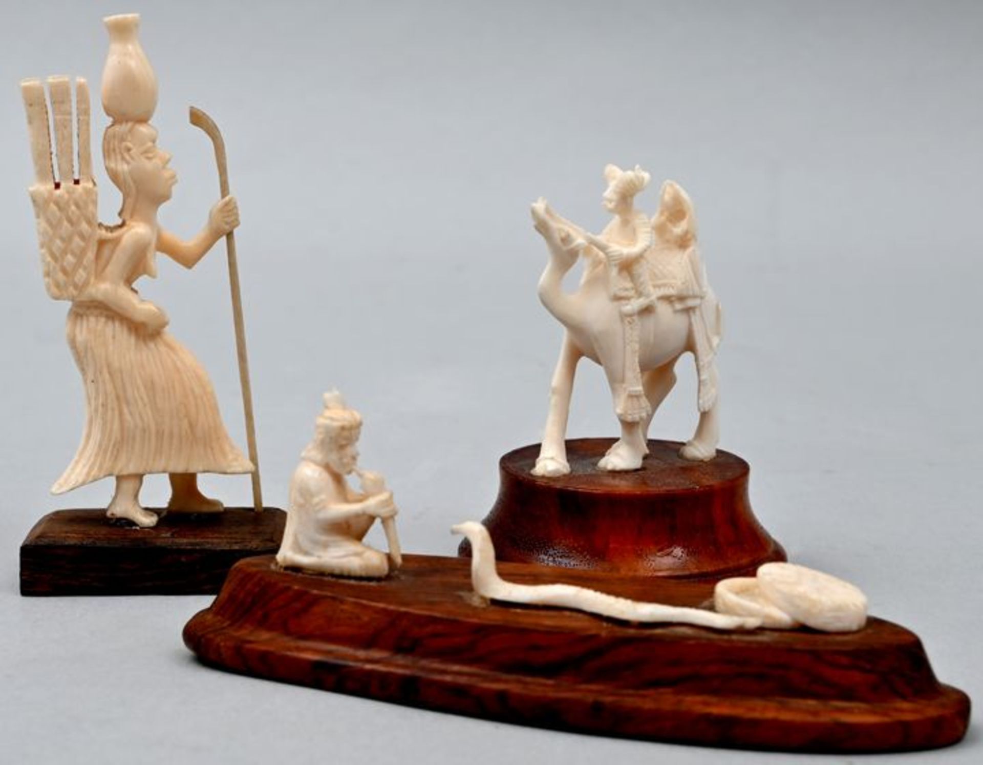 Drei Figuren, AfrikaElfenbein, Holz, hergestellt vor 1945 (1) Sammelnde Frau, auf einem Holzp
