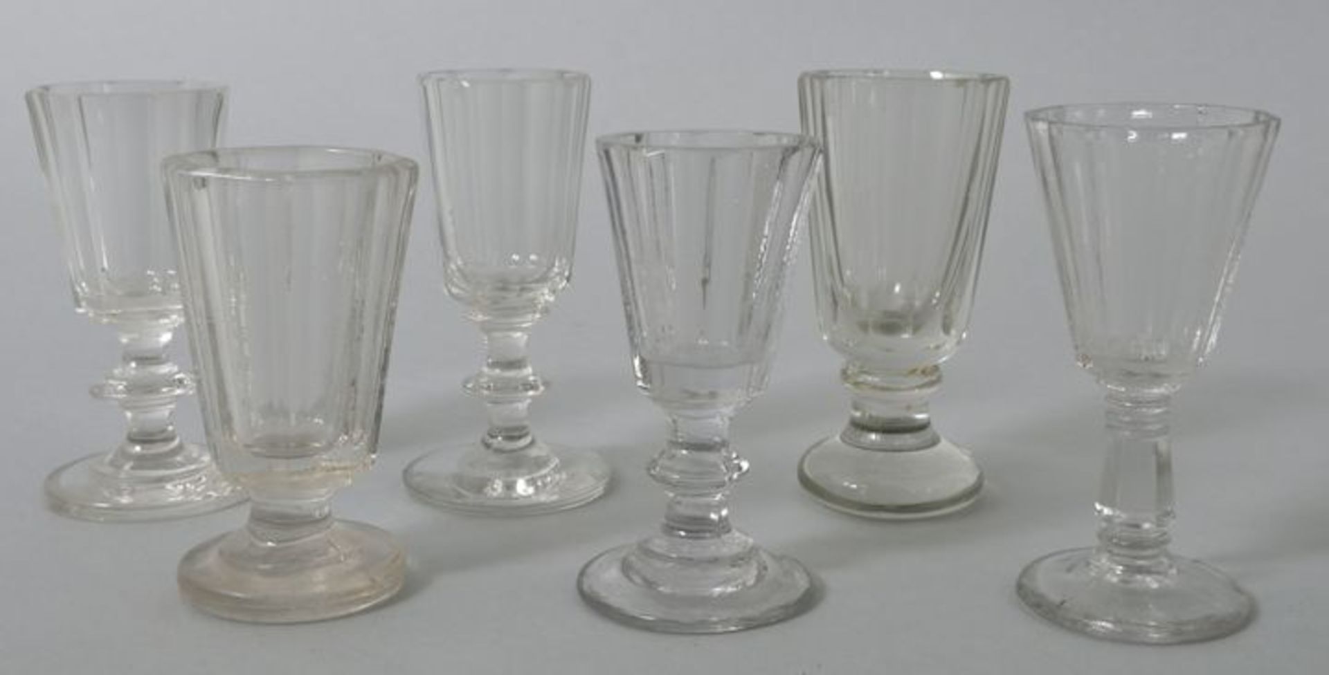 6 Schnapsgläser, deutsch, 2. H. 19. Jh.Farbloses Glas, 3 St. Pressglas, Kuppas facettiert. S