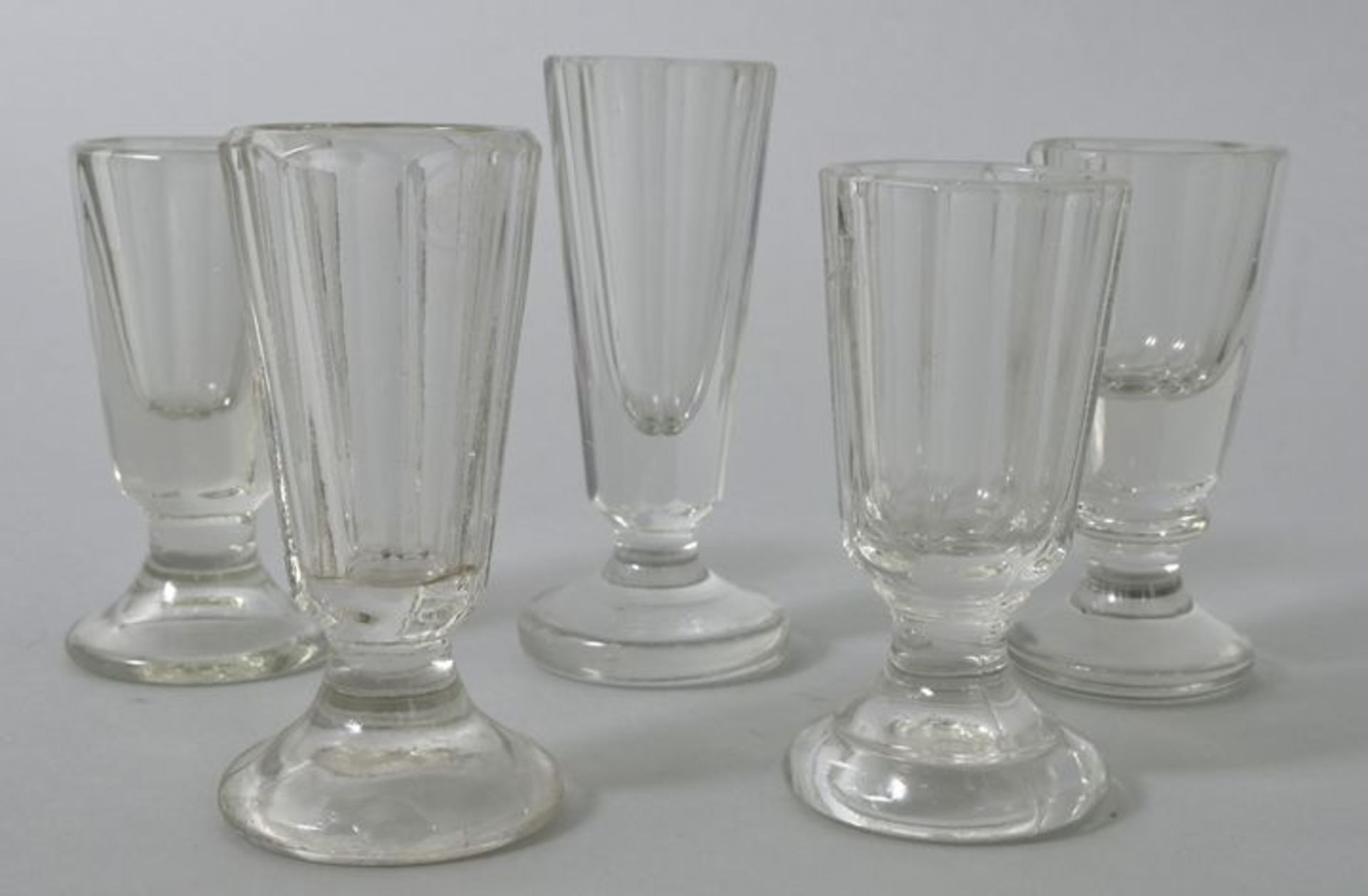 Fünf Schnapsgläser, 2. H. 19. Jh.Farbloses Glas, davon 3 St. Pressglas. Konische Kuppas fac