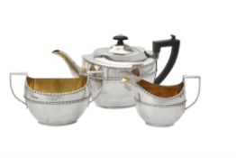 An Edwardian silver oval three piece tea set by Maxfield & Sons Ltd.