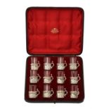 A cased set of twelve Victorian silver mounted liqueur glasses by William Comyns & Sons Ltd.