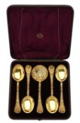 A cased set of four Victorian silver gilt fruit spoons and a sifting spoon by Henry William Curry