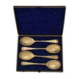 A cased set of four George III silver gilt Old English pattern berry spoons