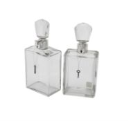 A pair of silver mounted lockable glass decanters by Hukin & Heath Ltd.