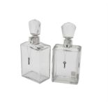 A pair of silver mounted lockable glass decanters by Hukin & Heath Ltd.