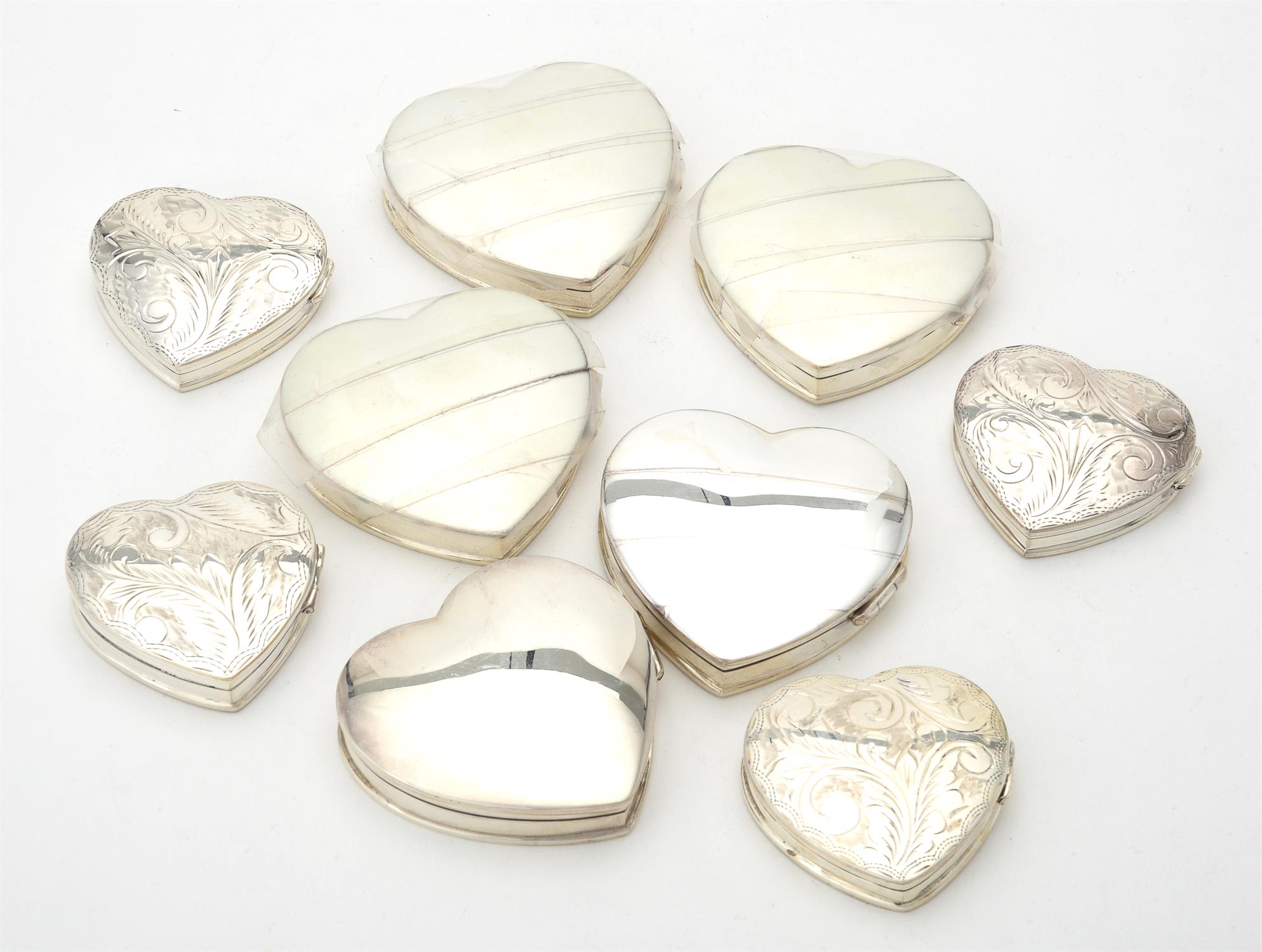 A collection of silver heart shaped boxes